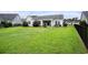 Expansive backyard featuring green grass, a black fence, and a patio area with seating at 380 Babylon Pine Dr., Myrtle Beach, SC 29579