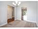 Bright dining area with carpet flooring, a modern chandelier, and views into the living space at 380 Babylon Pine Dr., Myrtle Beach, SC 29579
