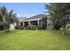 Well-maintained backyard featuring lush green lawn, mature landscaping, and a screened patio with comfortable seating at 388 Sea Turtle Dr., Myrtle Beach, SC 29588