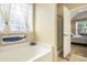Bright bathroom featuring a glass block window, soaking tub, open door to Primary bedroom and a glass shower at 388 Sea Turtle Dr., Myrtle Beach, SC 29588