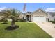 Beautiful one-story home features a lush lawn, a palm tree, and a two-car garage at 388 Sea Turtle Dr., Myrtle Beach, SC 29588