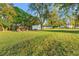 Large backyard with various outbuildings, lush green grass, and mature trees, providing plenty of space and storage at 3930 West Marion St., Mullins, SC 29574