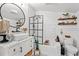 Bright bathroom features a white vanity, elegant fixtures, a bathtub with subway tile, and decorative shelving at 3930 West Marion St., Mullins, SC 29574