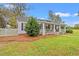 Charming single-story home with a welcoming front porch, complemented by a neatly landscaped yard and mature trees at 3930 West Marion St., Mullins, SC 29574