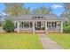Inviting home exterior with a charming porch, swing, and well-manicured lawn at 3930 West Marion St., Mullins, SC 29574