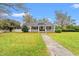 Quaint home featuring a covered porch and well-maintained lawn, complete with mature trees and a welcoming walkway at 3930 West Marion St., Mullins, SC 29574