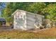 Charming white storage shed with double doors, accompanied by outdoor seating and rustic decor at 3930 West Marion St., Mullins, SC 29574