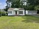 Charming single story home with white siding, brick porch and a two-car detached garage at 404 E Andrews St., Hemingway, SC 29554
