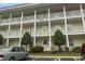 Close up on the condo building with parking, landscaping, and a sign at 4261 Hibiscus Dr. # 4-104, Little River, SC 29566