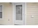 Front door with glass decorations, a screen door, a window, and cream-colored siding at 4261 Hibiscus Dr. # 4-104, Little River, SC 29566