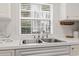 Close-up of a stainless steel sink with a window above looking out on green trees at 4261 Hibiscus Dr. # 4-104, Little River, SC 29566