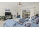 Well-lit living room featuring a blue sofa and chair, and sliding glass doors with white curtains at 4261 Hibiscus Dr. # 4-104, Little River, SC 29566