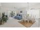 Bright living room with blue sofa, white walls, and a dining area with a glass table at 4261 Hibiscus Dr. # 4-104, Little River, SC 29566