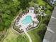 Aerial view of a community pool with lounge chairs, palm trees, and a nearby pool house at 4261 Hibiscus Dr. # 4-104, Little River, SC 29566