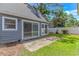 Backyard featuring sliding glass doors, a small patio, and a green lawn, perfect for outdoor relaxation at 4532 Spyglass Dr., Little River, SC 29566