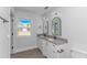 This bathroom features double sinks with granite counters and two arched mirrors over a vinyl floor at 4532 Spyglass Dr., Little River, SC 29566