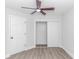 Minimalist bedroom with wood floors, ceiling fan, and white closet doors at 4532 Spyglass Dr., Little River, SC 29566