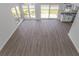 A spacious living room with a view of the backyard, sliding glass doors, and wood-look vinyl floors at 4532 Spyglass Dr., Little River, SC 29566