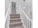 Carpeted stairway to the second floor with white wood railings and an eye-catching modern light fixture at 4532 Spyglass Dr., Little River, SC 29566