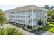 Three-story condo building featuring white balconies, stairs, and a decorative stone facade at 4655 Wild Iris Dr. # 41-303, Myrtle Beach, SC 29577