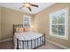 Well-lit bedroom featuring a black metal bed frame, striped bedding and two windows with views of the outdoors at 5 Ruth St., Murrells Inlet, SC 29576