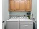 Functional laundry area equipped with a side-by-side washer and dryer and overhead storage cabinets at 5 Ruth St., Murrells Inlet, SC 29576