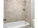 Tiled bathroom with tub and shower head showcasing a neutral palette and providing a clean, comfortable space at 55 Pineberry Dr., Georgetown, SC 29440