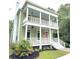 Charming two-story home featuring a double porch, white columns, and a vibrant pink front door at 55 Pineberry Dr., Georgetown, SC 29440