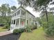 Elegant two-story home surrounded by mature trees, featuring double porches and a brick walkway at 55 Pineberry Dr., Georgetown, SC 29440