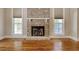 Living room featuring a classic brick fireplace flanked by windows and beautiful hardwood floors at 55 Pineberry Dr., Georgetown, SC 29440