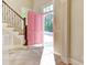 Welcoming foyer with stone tile flooring, a pink front door, and a staircase with decorative iron railings at 55 Pineberry Dr., Georgetown, SC 29440
