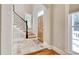 Inviting foyer with stone tile flooring, wood door, and a staircase with decorative iron railings at 55 Pineberry Dr., Georgetown, SC 29440