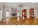 Spacious living room with a brick fireplace, hardwood floors, large windows, and an open floor plan at 55 Pineberry Dr., Georgetown, SC 29440