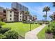 Beautiful condo complex featuring manicured lawns, tropical palm trees, and a pathway to the beach at 5505 N Ocean Blvd. # 303, Myrtle Beach, SC 29577