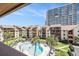 Aerial view of a condo complex, pool, palm trees, and manicured lawns with an ocean view at 5505 N Ocean Blvd. # 303, Myrtle Beach, SC 29577