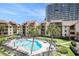 Aerial view of the condo pool, featuring palm trees, lounge chairs, and lush green lawns at 5505 N Ocean Blvd. # 303, Myrtle Beach, SC 29577