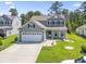 Charming two-story home featuring gray siding, a two-car garage, and a well-manicured front yard with green grass at 597 Heritage Downs Dr., Conway, SC 29526