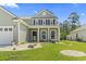 Inviting two-story home with neat landscaping, a well-maintained lawn, and a charming entrance at 597 Heritage Downs Dr., Conway, SC 29526