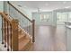 Bright and airy living room with hardwood floors, a ceiling fan, and staircase with decorative iron spindles at 597 Heritage Downs Dr., Conway, SC 29526