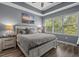 Comfortable primary bedroom with a tray ceiling, a serene color palette, a large window, and wood-look floors at 6015 Catalina Dr. # 932, North Myrtle Beach, SC 29582