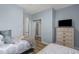 Bedroom with light blue walls, featuring two twin beds, a mirrored closet, and a chest of drawers with a TV at 6015 Catalina Dr. # 932, North Myrtle Beach, SC 29582