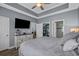 Primary bedroom featuring tray ceiling, ceiling fan, mounted TV, a walk in closet, and neutral paint colors at 6015 Catalina Dr. # 932, North Myrtle Beach, SC 29582