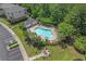 Aerial view of a community pool surrounded by chairs, lush landscaping, and a nearby parking lot at 6015 Catalina Dr. # 932, North Myrtle Beach, SC 29582