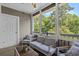 Relaxing screened porch with cozy seating, ceiling fan, views of the trees and an access door to the backyard at 6015 Catalina Dr. # 932, North Myrtle Beach, SC 29582
