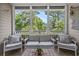 Inviting screened porch offers a relaxing space with comfortable seating and serene views of mature trees at 6015 Catalina Dr. # 932, North Myrtle Beach, SC 29582