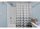 Bathroom with shower-tub combination, gray and white striped shower curtain, and decorative starfish at 6015 Catalina Dr. # 932, North Myrtle Beach, SC 29582