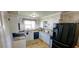 Well-lit kitchen featuring a black refrigerator, black dishwasher, and white cabinets at 610 Hibiscus Ave. # 610, Myrtle Beach, SC 29572