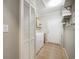 Well-lit laundry room featuring tile floors, washer, dryer, and ample storage space behind a paneled closet door at 628 Lake Estates Ct., Conway, SC 29526