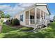 A view from the rear of the home features a well-maintained yard and a cozy covered porch with white railings at 628 Lake Estates Ct., Conway, SC 29526