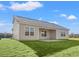 Expansive backyard showcasing the home's rear exterior, a covered patio, and lush green lawn at 651 Snowy Owl Way, Conway, SC 29527